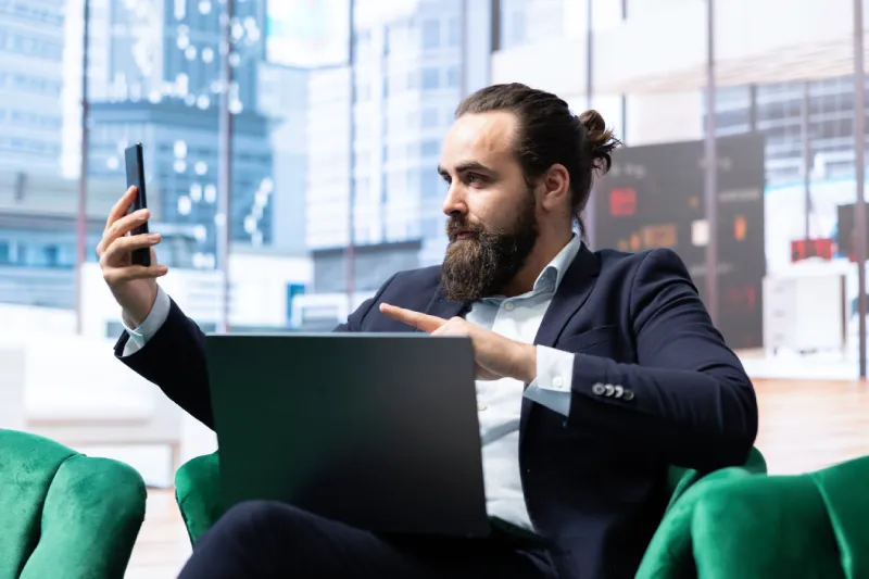 Businessmann hält Smartphone in der Hand und filmt