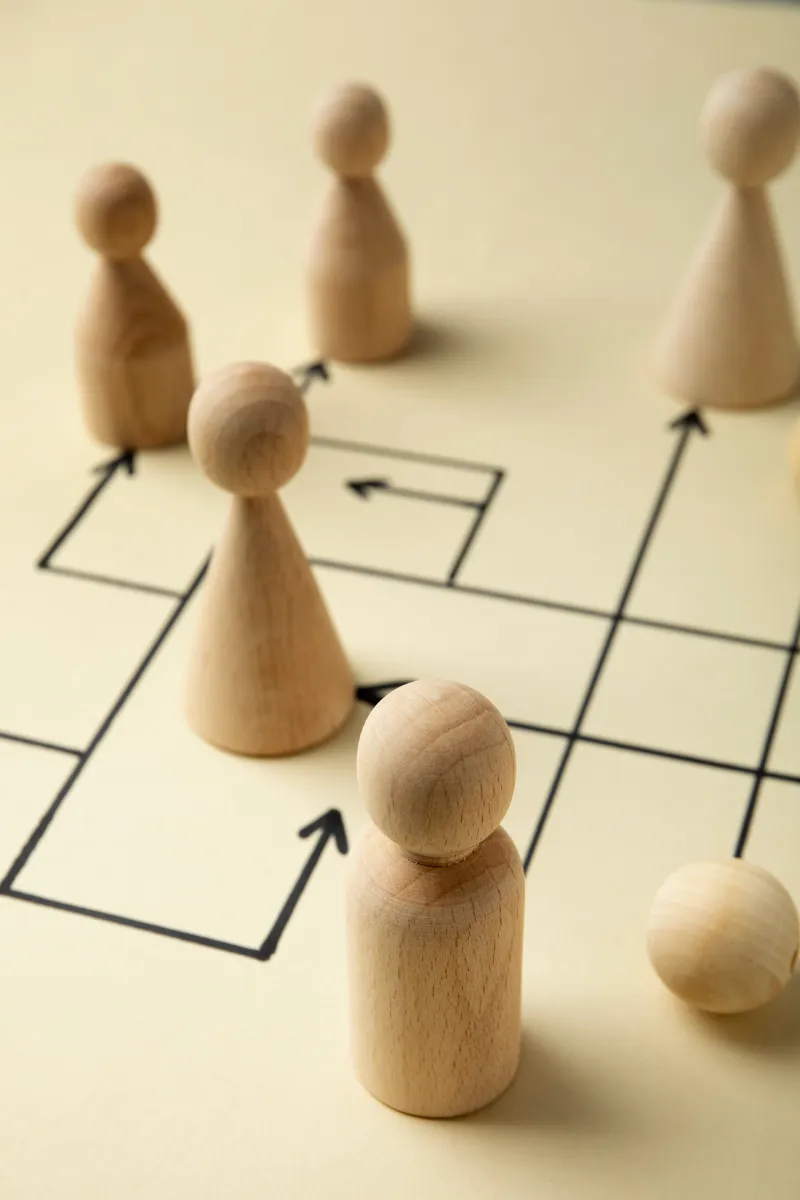 Spielfiguren stehen auf einem Brett mit Wegweisern