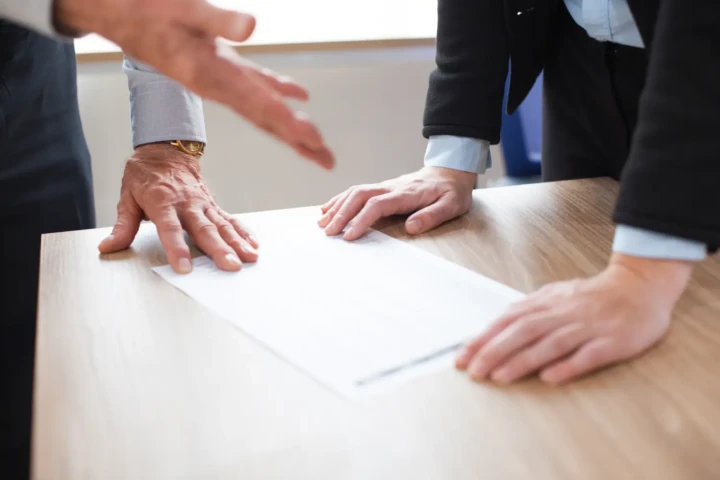 Geschäftsmänner besprechen ein auf dem Tisch liegendes Dokument
